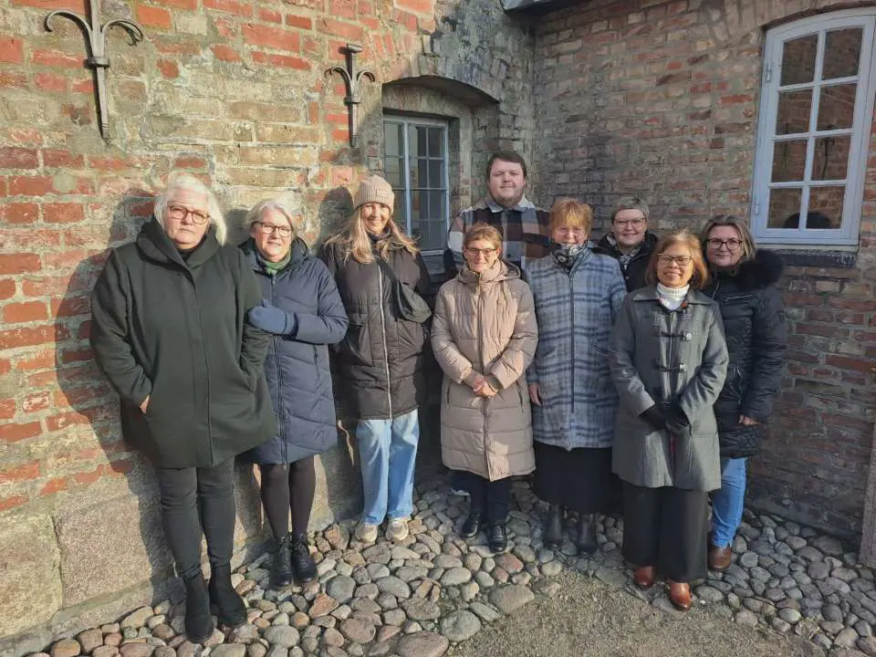Pauline Weltman med den ternede blå jakke og otte af hendes kollegaer fra hjemmeplejen var med til at sige et sidste farvel til en ældre kvinde, de alle havde passet. 