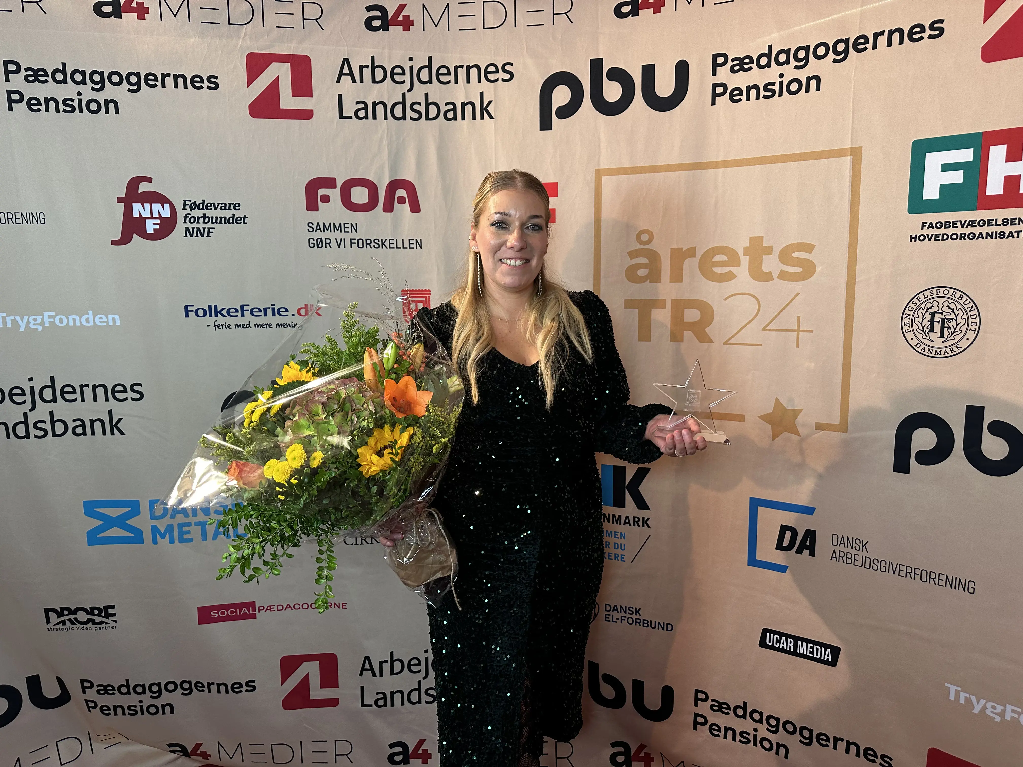 Mie Christensen står med medalje og en blomsterbuket i hånden, efter hun er blevet kåret som årets AMR 2024.